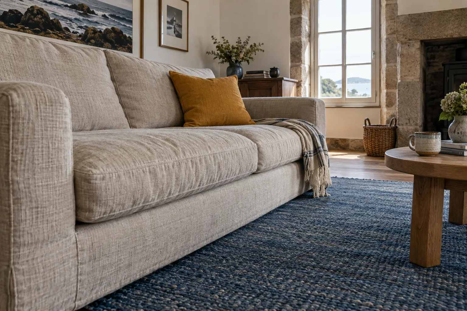 Canapé en tissu clair et tapis bleu dans un salon